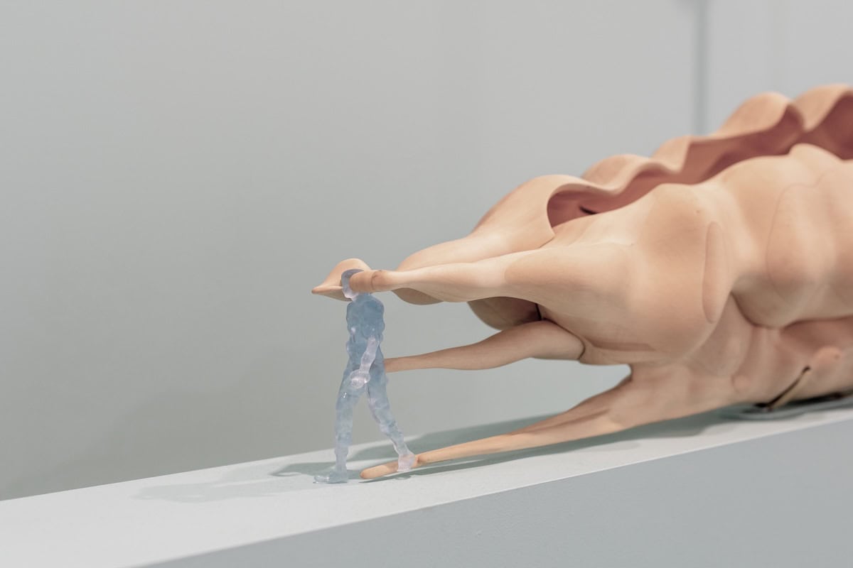 A sculpture depicting a person walking with abstract shapes billowing behind them. 