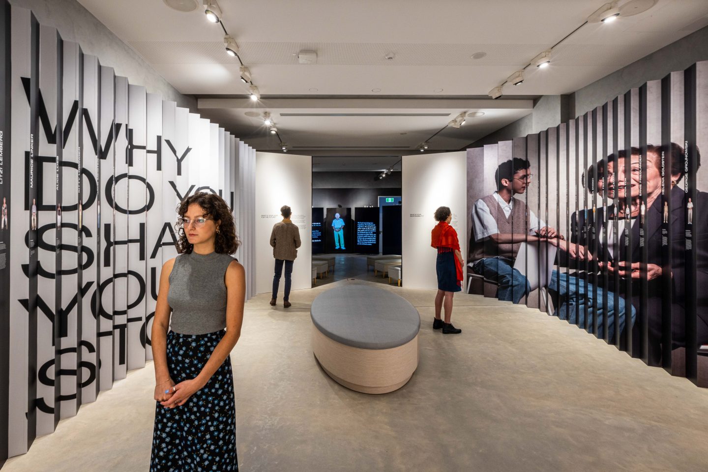 three people looking at an art exhibit. 